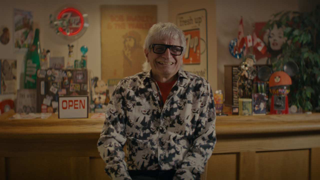 a man with thick framed glasses smiling